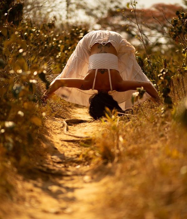 Woman in a graceful yoga pose with warm amber light accents.